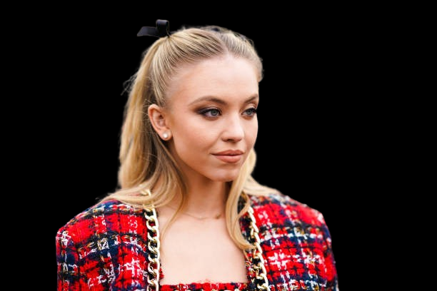 Sydney Sweeney stuns in a silver Anti-Bridal Corset at CinemaCon 2025, styled with a bold belt and soft glam beauty look.