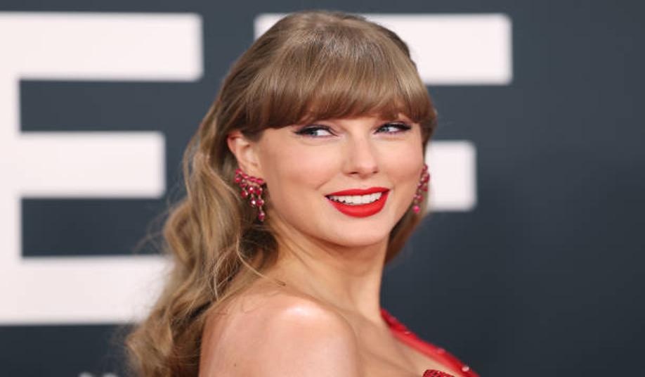 Taylor Swift wearing orange lipstick on Travis Kelce’s podcast.