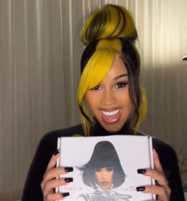 Cardi B’s Chunky Yellow Highlights Just Resurrected Myspace Hair Trends 1 Cardi B showing off bright yellow chunky highlights in a messy bun, matching her new yellow vinyl album edition.