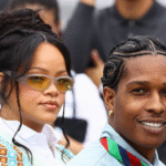 Rihanna and A$AP Rocky holding newborn daughter Rocki Irish Mayers, with sons RZA and Riot smiling alongside them in a family photo.