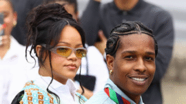 Rihanna and A$AP Rocky holding newborn daughter Rocki Irish Mayers, with sons RZA and Riot smiling alongside them in a family photo.