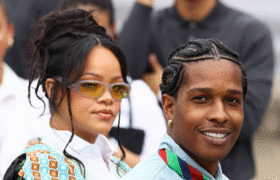 Rihanna and A$AP Rocky holding newborn daughter Rocki Irish Mayers, with sons RZA and Riot smiling alongside them in a family photo.