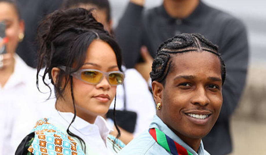 Rihanna and A$AP Rocky holding newborn daughter Rocki Irish Mayers, with sons RZA and Riot smiling alongside them in a family photo.
