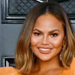 Chrissy Teigen smiling after losing a dental veneer during a holiday Instagram moment