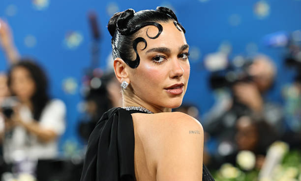 Dua Lipa rainbow confetti nails with chrome silver base and colorful glitter nail art for New Year’s Eve