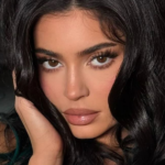 Kylie Jenner wearing a Santa red latex dress at a holiday party with glossy red manicure and sleek hair styling