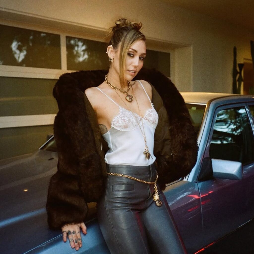 Miley Cyrus Just Made ‘90s Prom Hair Look Like an Everyday Thing 3 Miley Cyrus 90s hairstyle trend with high bun and face-framing tendril