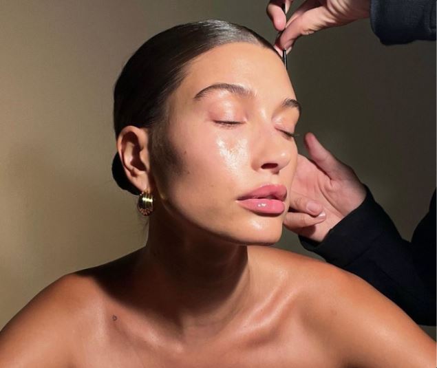 Minimalist skinimalism skincare routine layout with five essential products including cleanser, serum, moisturizer, toner, and sunscreen