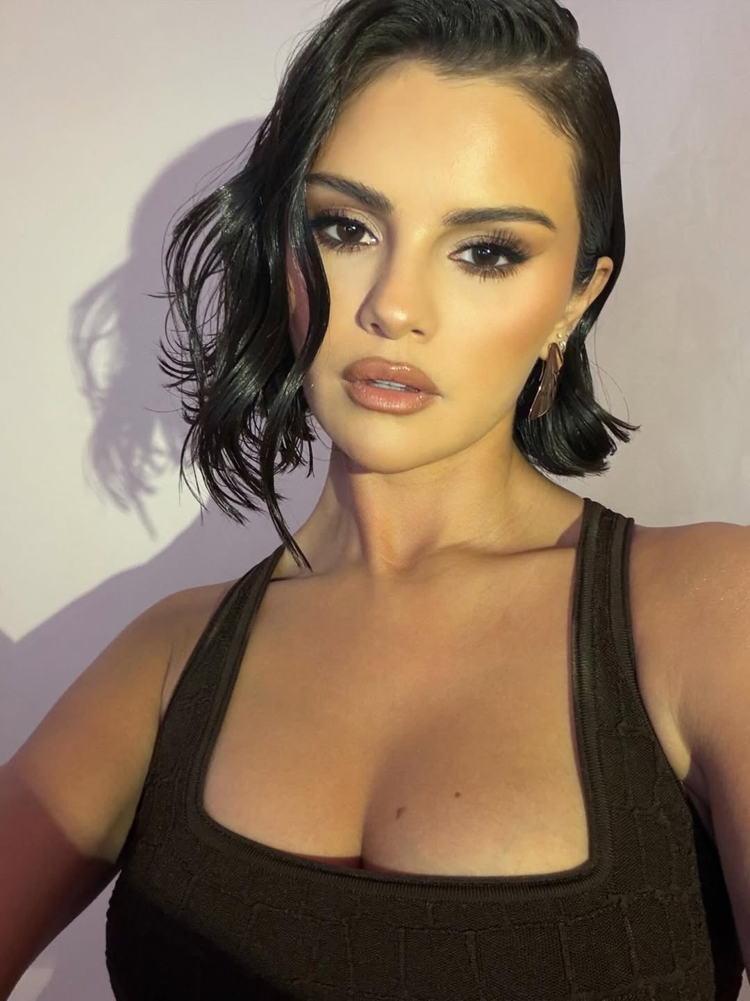 Selena Gomez showing off metallic bronze shimmer nails with a glossy, sun-kissed finish during winter