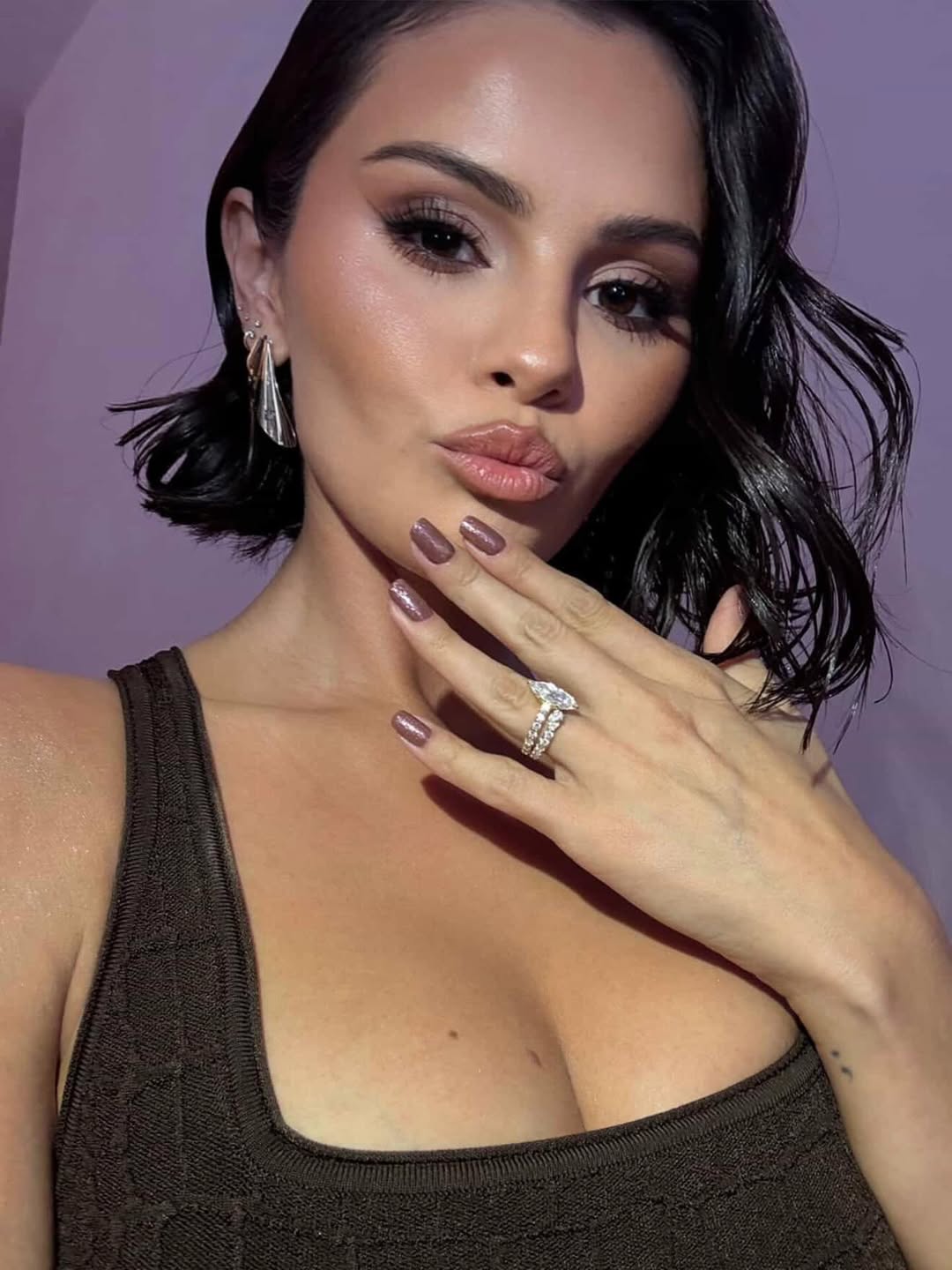 Selena Gomez showing off metallic bronze shimmer nails with a glossy, sun-kissed finish during winter