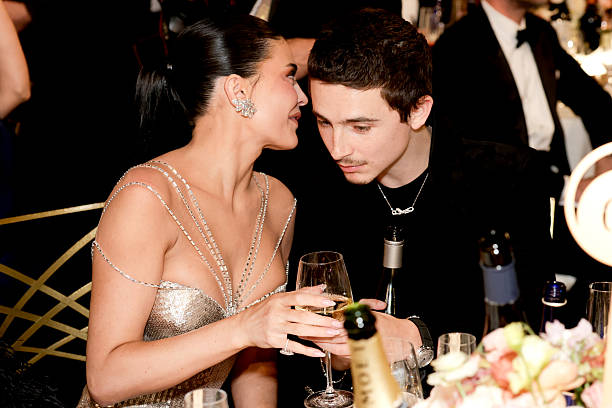 Timothée Chalamet and Kylie Jenner seated together at the Golden Globes during a tense viral moment before their awkward kiss